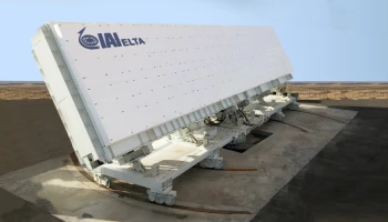 A large, white, rectangular radar system with the logo IAI ELTA on its side is positioned outdoors on a concrete base in a barren, desert-like area under a pale blue sky.