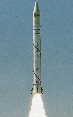 A white rocket with blue markings and symbols, reminiscent of the Ofek 1 launch, soars into the sky, emitting bright flames and smoke from its base against a clear background.