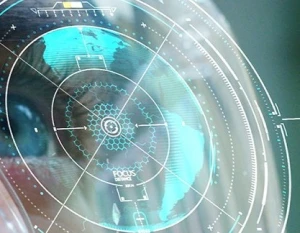A close-up of a human eye reflects a transparent digital interface with blue and white circular graphics, lines, and data, evoking futuristic technology often found at an innovation center.