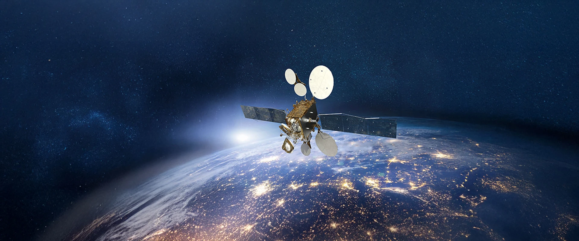 The DROR 1 satellite, with large antennas or solar panels, orbits above the illuminated surface of Earth at night, with city lights visible and a starry space background.