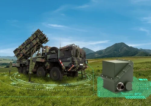 A military vehicle with a mounted missile launcher is parked on grassy terrain with hills and mountains in the background. A digitally highlighted north finding system is visible in the foreground.