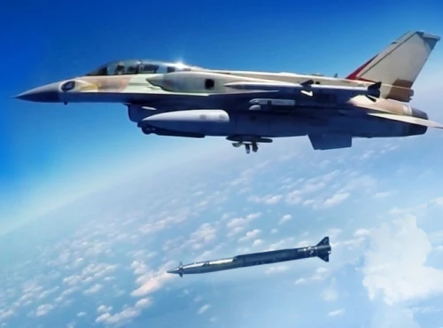 A military jet flies high above the clouds, releasing a to ground missile that is descending toward the earth. The sky is clear and blue, with the jet and missile sharply visible in the foreground.