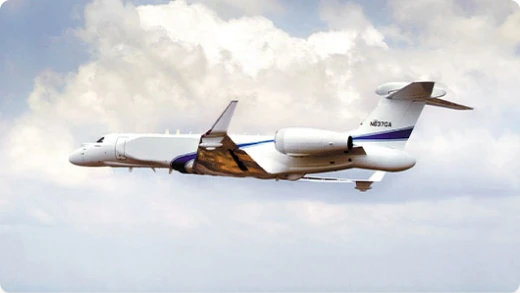 A white and blue jet aircraft with large engines flies against a cloudy sky. The airplane has a distinctive radar dome on top and a U.S. registration number N872D on the tail.