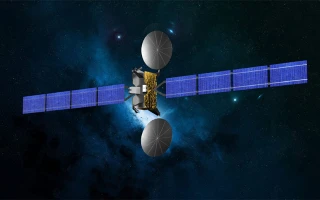 A satellite with large blue solar panels and two round antennas or dishes floats in space against a dark, star-filled background.