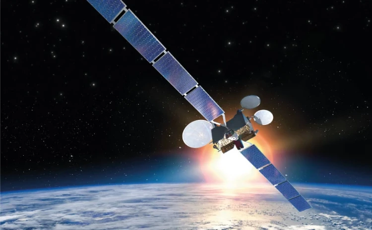 A satellite with large solar panels, developed by IAI, orbits above Earth, with the planet’s surface and clouds visible below and a bright sunburst in the background against a starry sky.