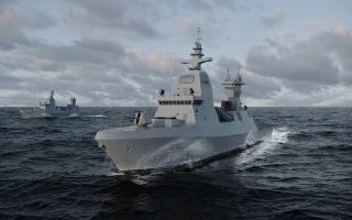 Two modern grey naval warships, equipped with advanced Hanwha Systems technology, travel across choppy ocean waters under a cloudy sky, with one ship in the foreground and the other in the distance.