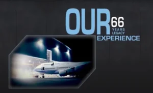 A large IAI airplane is parked outside a hangar at night, illuminated by bright lights. The text beside it reads OUR 66 YEARS MRO LEGACY EXPERIENCE in bold blue and white letters on a dark background.