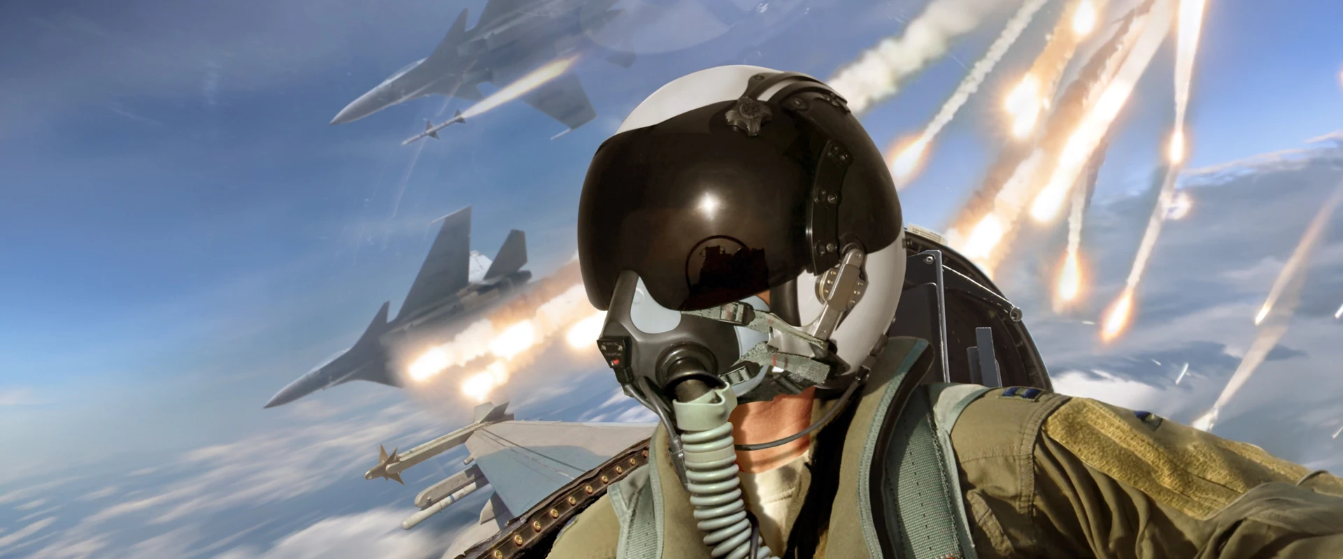 A fighter pilot in a helmet and oxygen mask takes a selfie in the cockpit mid-flight; several jets and bright flares are visible against a blue sky in the dramatic background.