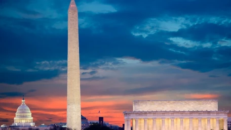 View of the Washington Monument, U.S. Capitol, and Lincoln Memorial at sunset, with a colorful sky of blue, orange, and purple hues in Washington, D.C.