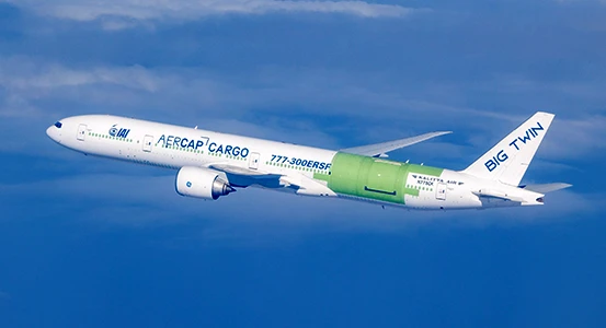 A white cargo airplane with blue “AERCAP CARGO” text and a green section near the center flies above the clouds. The tail fin says “BIG TWIN” in large letters.